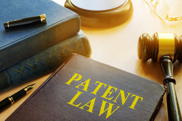 Patent law book with gavel and glasses.