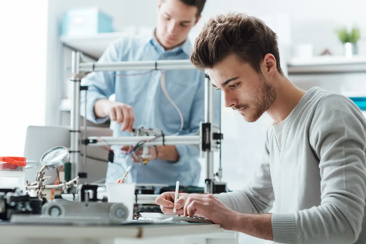 Two men working on 3D printer.